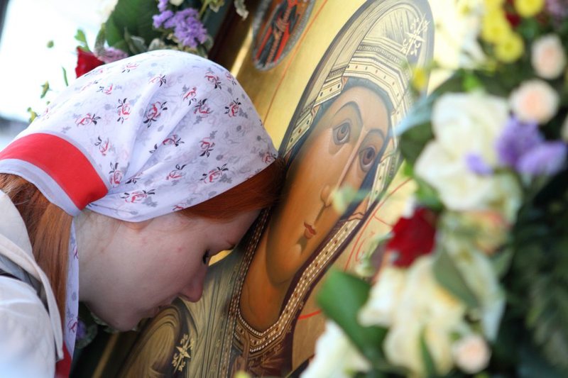 Dievča sa ukloní pred ikonou Panny Márie