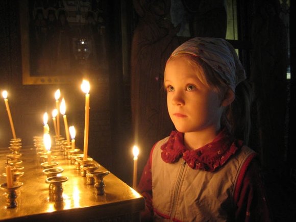 Kind bidt in de kerk