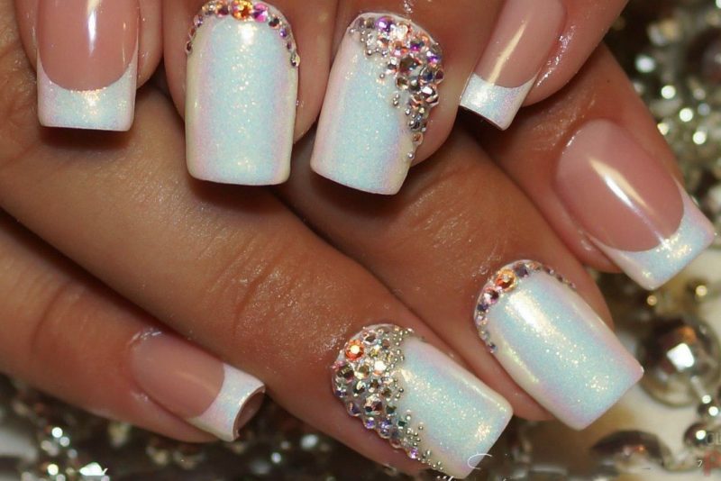 Parelmoer witte manicure met strass steentjes en een jas