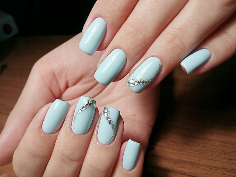 Ongles bleu ciel avec une vague de strass