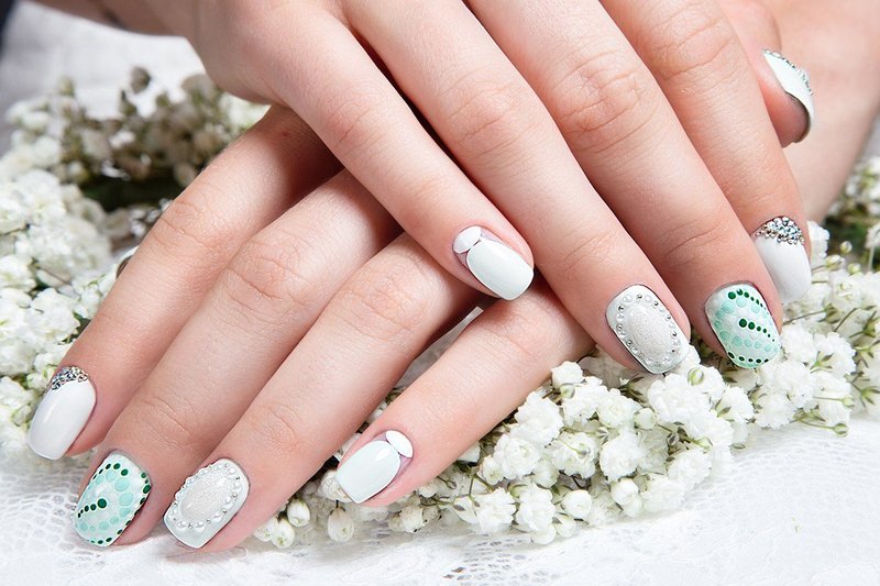 Blanc avec des ongles turquoises avec des strass et de l'argent