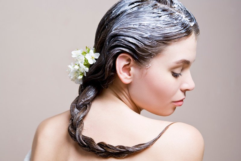 Fille avec un masque nourrissant sur ses cheveux