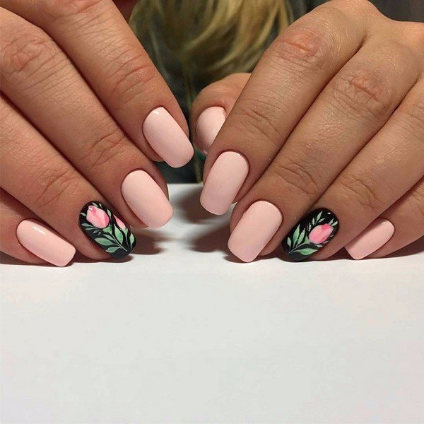 Manicure naakt met bloemen op een zwarte basis.