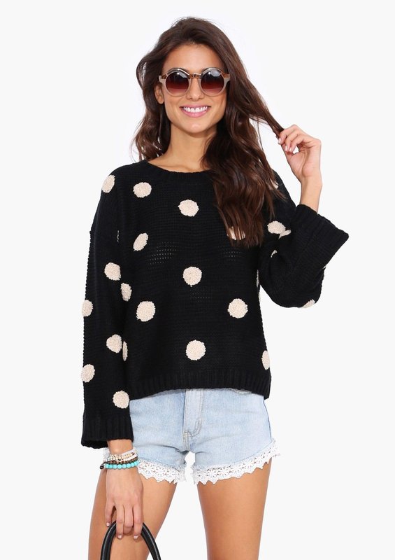 Fille dans un pull en gros pois et short.