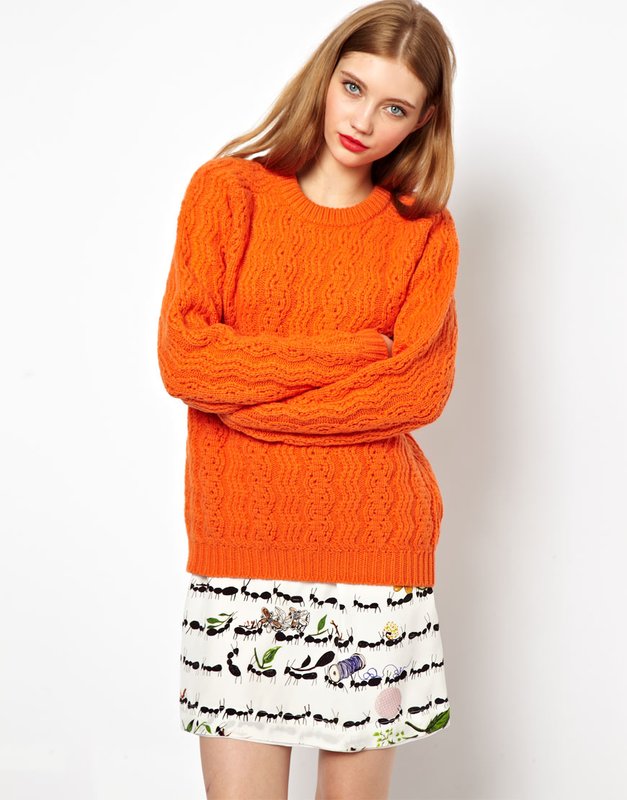 Fille en pull orange et jupe