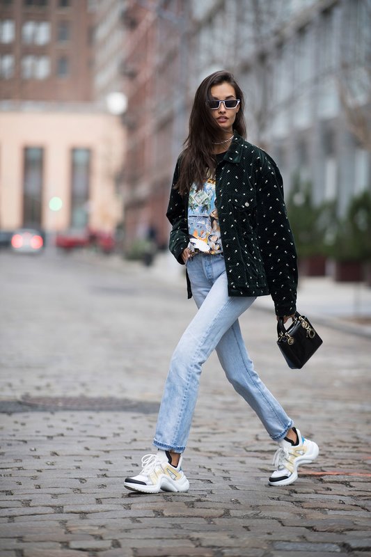 Una chica con zapatillas voluminosas combinadas con jeans