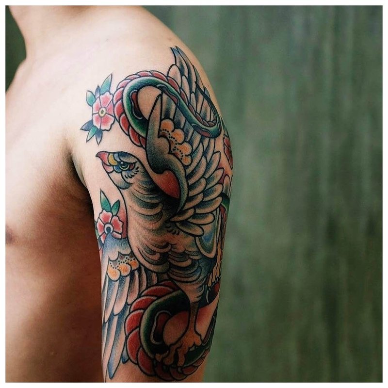 Tatouage avec un oiseau sur son épaule