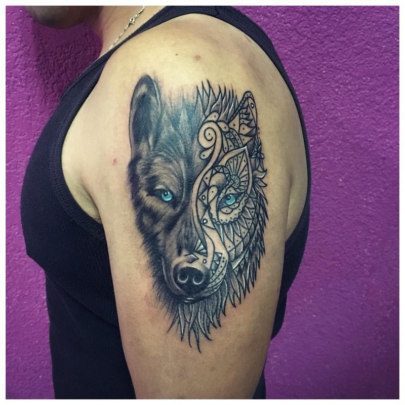 Mix van stijlen - een wolfentattoo op de arm van een man