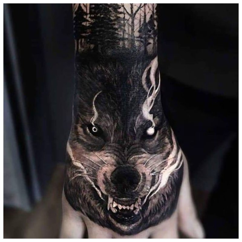 Wolfs mondtattoo op de hand van een man