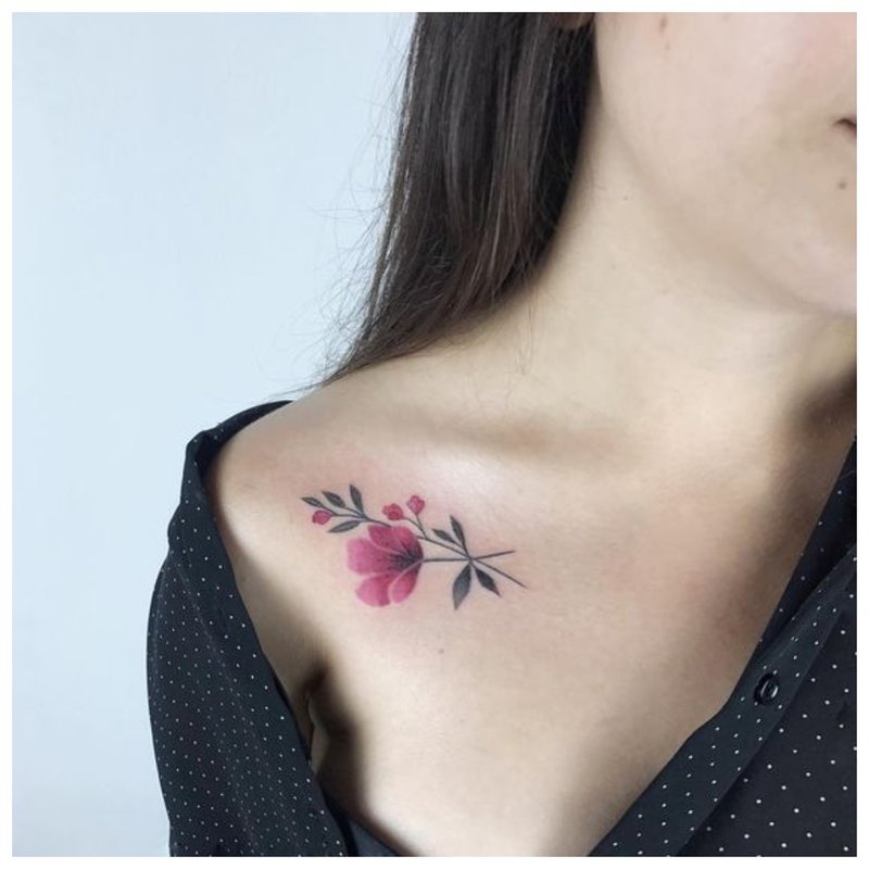 Delicate bloemtattoo op het sleutelbeen