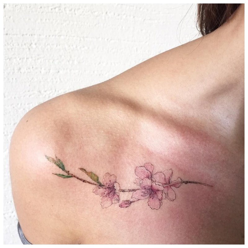 Delicate bloemtattoo op het sleutelbeen